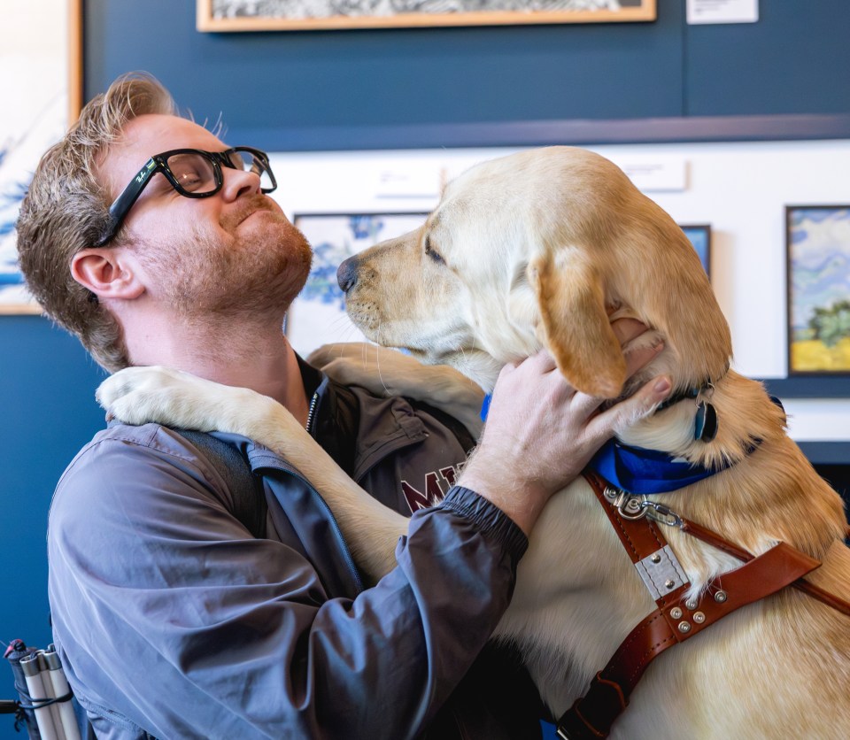 Photo of James Rath wearing Meta AI glasses with his guide dog, Hoagie