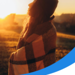 A lady closing her eyes facing sunrise scene