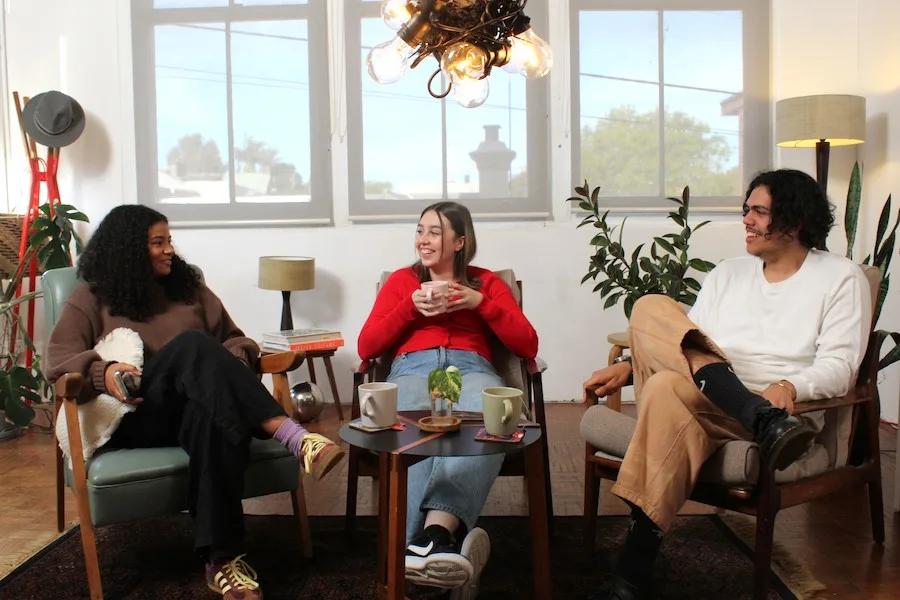 Anisha, Mia and Alex sitting inside chatting