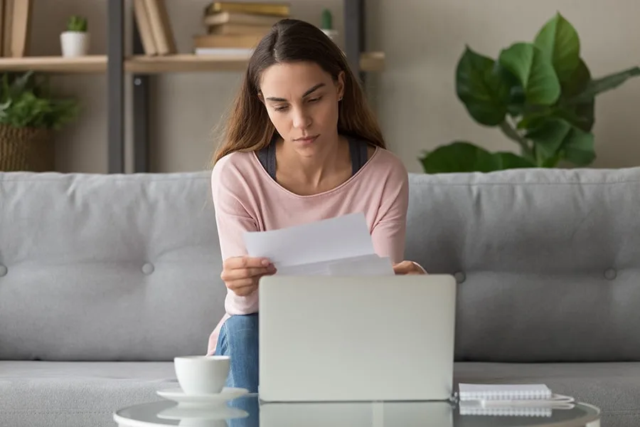 girl holding letter sitting on couch