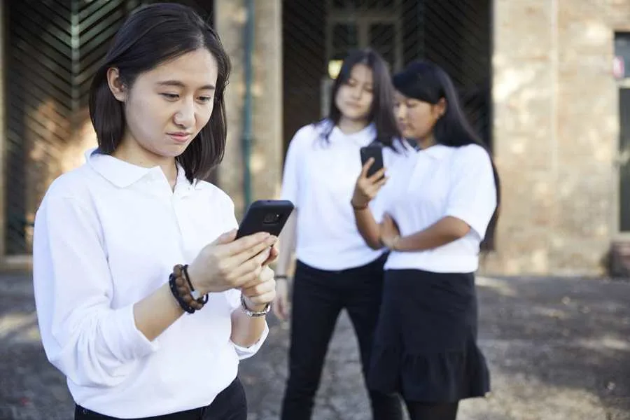 Girl at school looking at phone